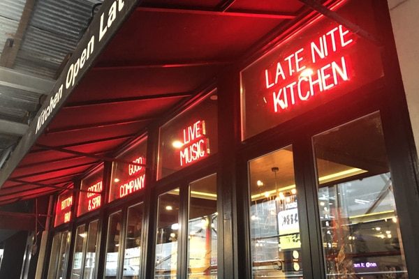 This image shows multiple SpellBrite signs, with one LED sign in each window, showing off messages like “Late Night Kitchen,” “Live Music,” and more.
