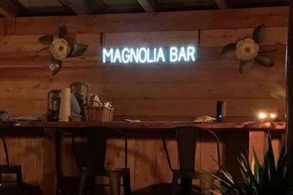 This custom light sign spells out “Magnolia Bar.”