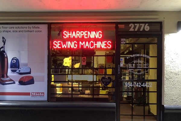 One of SpellBrite’s custom LED neon signs that states “Sharpening” and “Sewing Machines” on two lines.