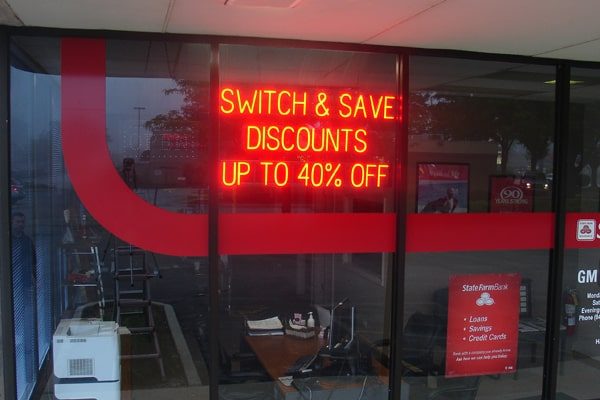 This LED light sign advertises “Switch & Save Discounts Up To 40% Off.”